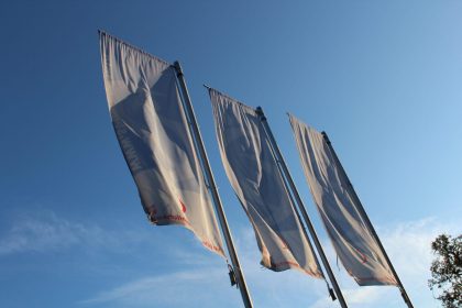 Drei Fahnen vor blauem Himmel