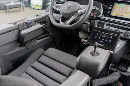 Leicht seitliche Innenaufnahme des VW-T6.1 Cockpit, barrierefrei eingerichtet und ausgestattet, mit Navigation, Touchsteuerung